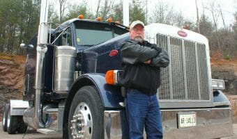 Experienced Veteran Truck Driver Smart Trucking Leaning on 379 Peterbilt