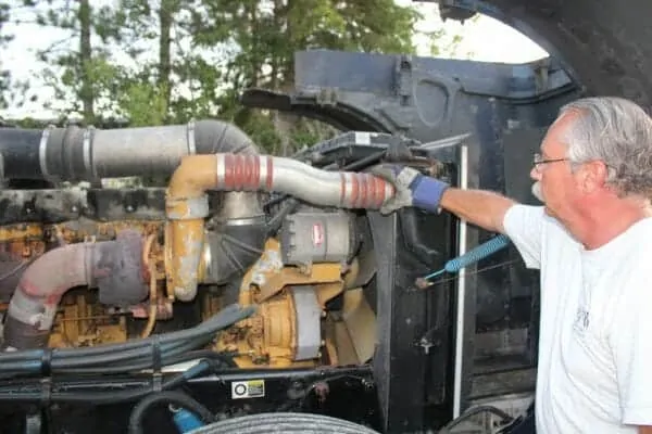 Trucker Fixing Caterpillar Diesel Engine