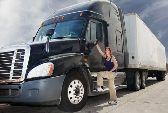 Woman Truck Driver Getting into Black Big Rig