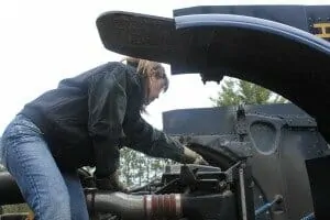 Female trucker fixing engine