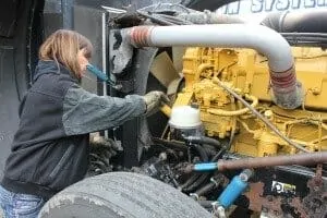 Lady trucker fixing big rig