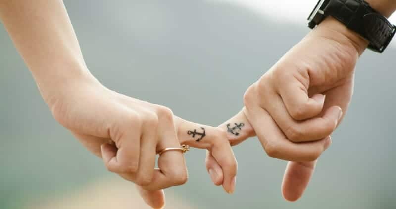 Couple with tattoo holding hands