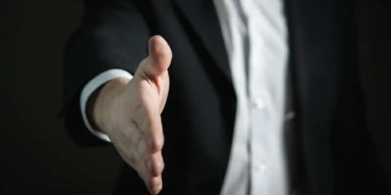 Salesman extending hand to shake on a deal