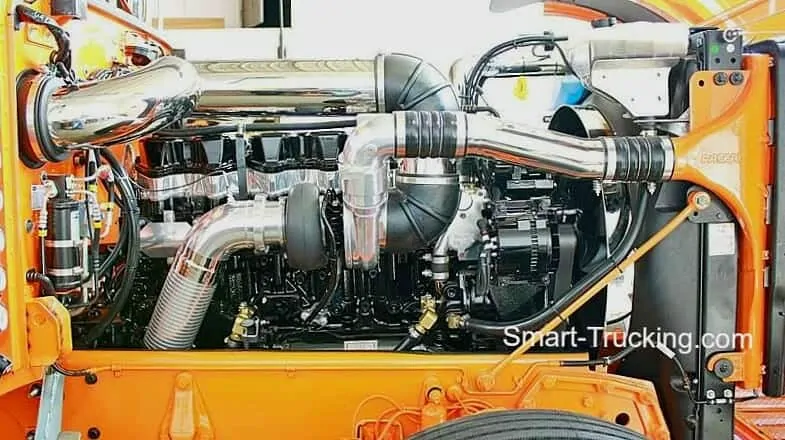 A photo of a CAT engine, produced by Caterpillar engines, from the side. The engine has chrome details and sits in an orange casing.