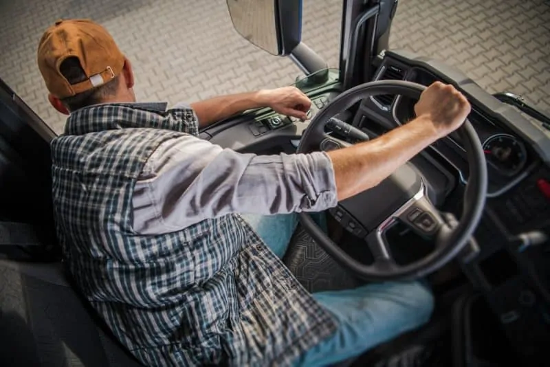 Truck driver backing up a big rig