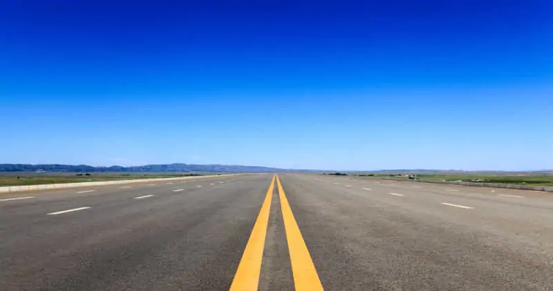 highway against a blue sky, long road stretching out into the distance