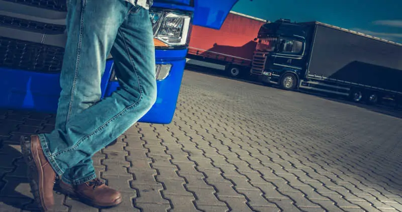 Truck driver leaning against his truck 