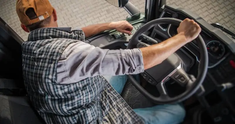 Truck driver backing up a big rig