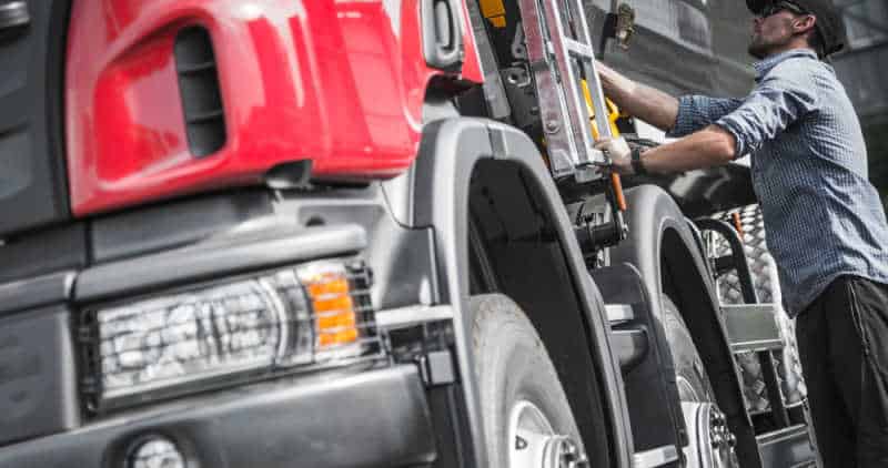 Truck driver working on truck