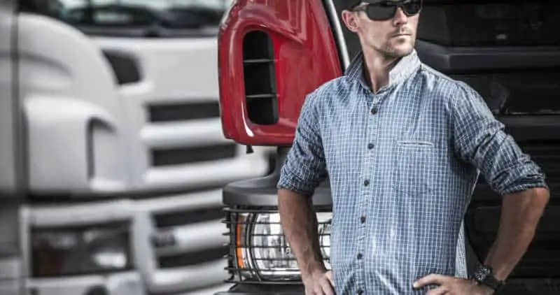 Trucker standing in front of a truck