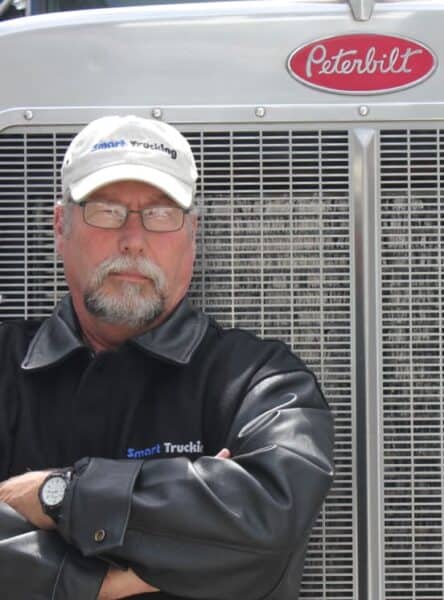 truck driver standing in front of his peterbilt truck