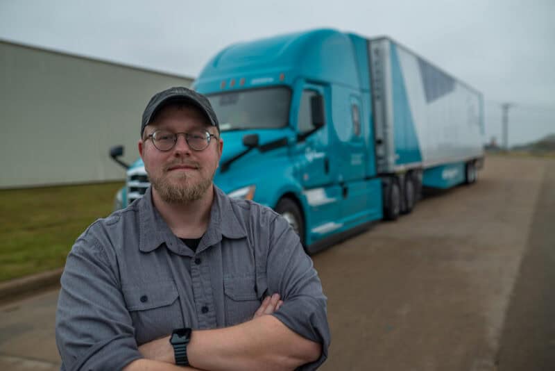 New truck driver standing by his semi truck