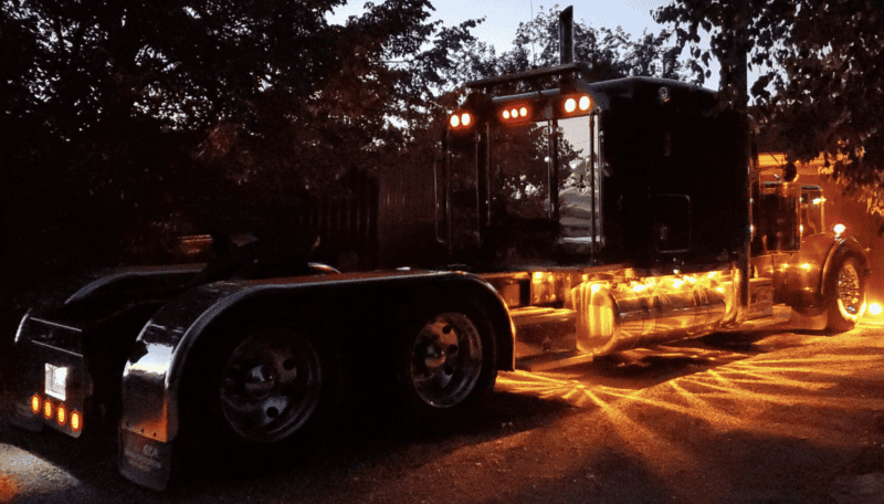 Long Nose Peterbilt Truck, at night, with highlighted feature lights. 