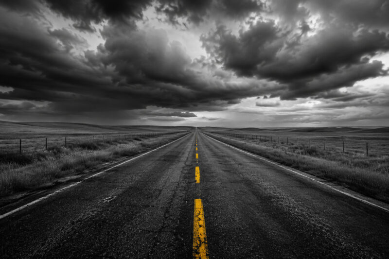 Desolate highway under stormy skies