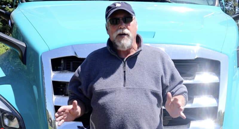 Truck driver standing in front of a Freightliner Cascadia